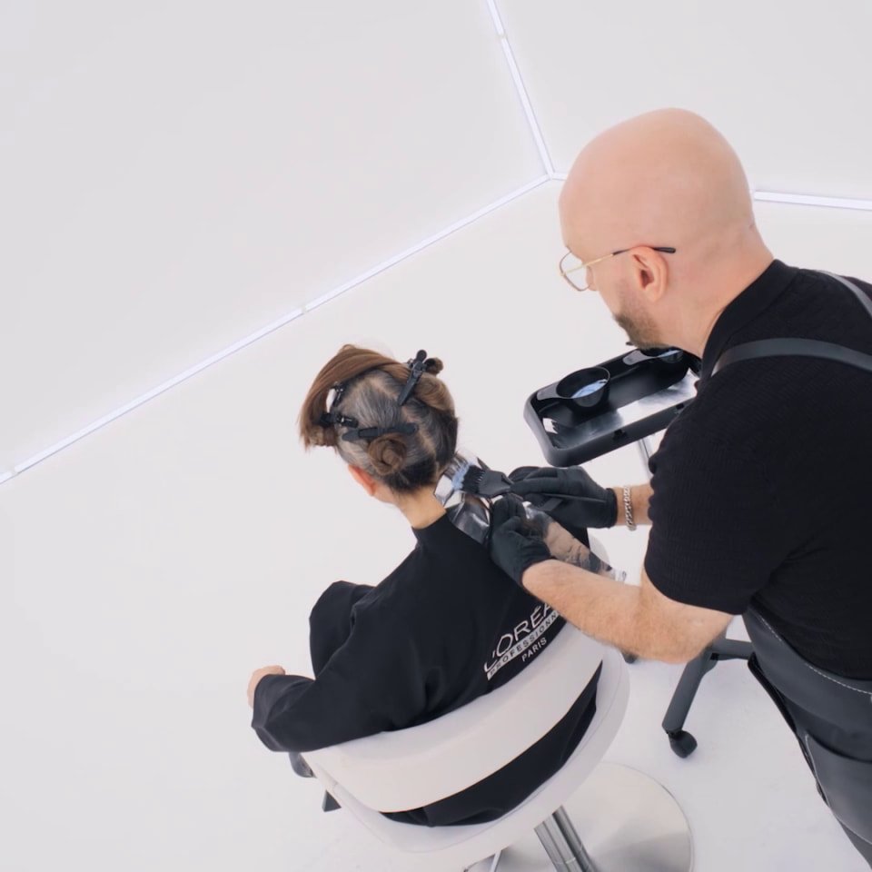 Hair colorist applying French Blending™ Vertical Weaving technique on a client in salon
